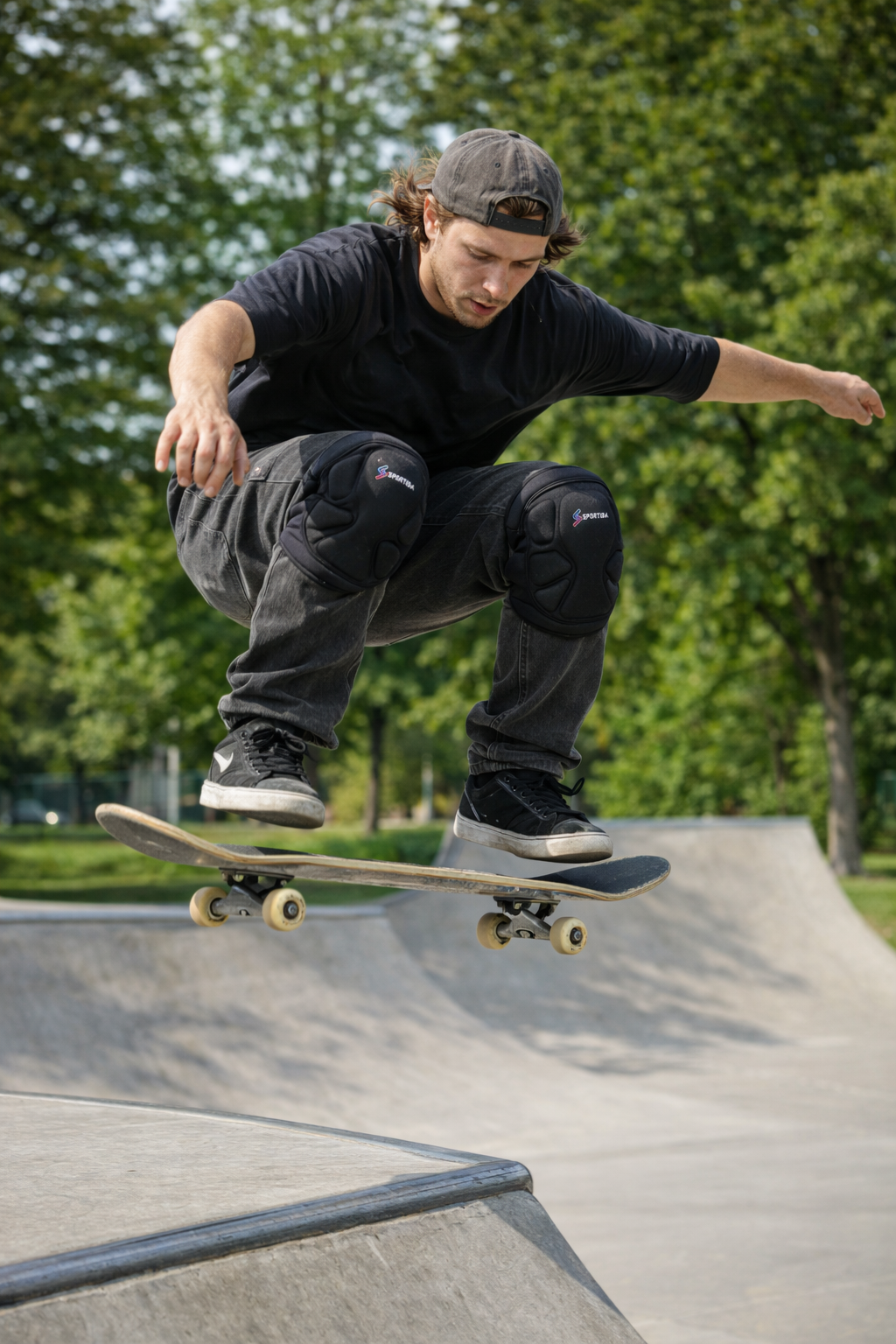 Skateboarder performing ollie in skatepark with knee pads for concrete durability